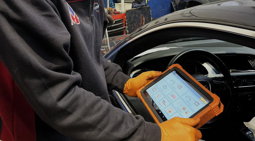 Foto mecánico revisando coche