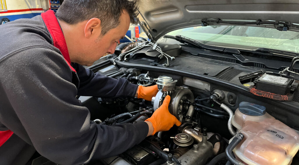 Foto de mecánico cambiando pieza motor